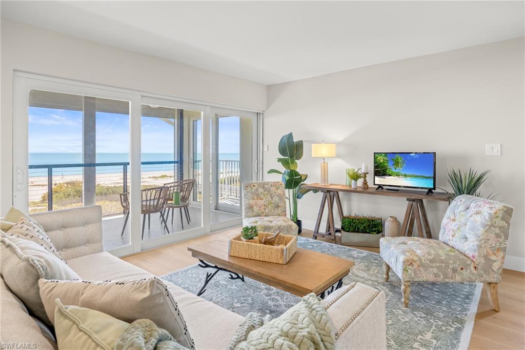 Image 4: Living room featuring light wood finished floors and a beach view