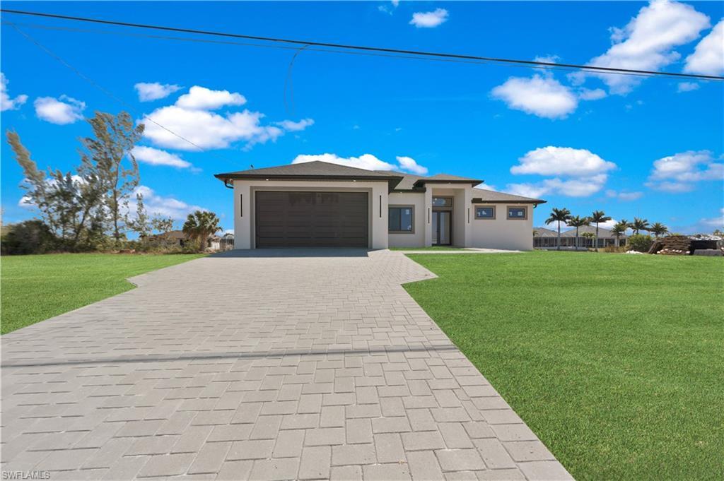 Image 3: Prairie-style house featuring a front lawn, decorative driveway, an attached garage, and stucco siding