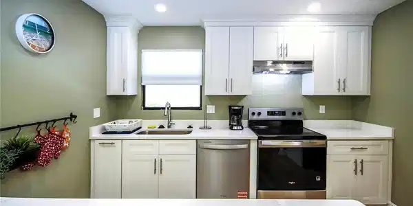 Image 4: Kitchen with white cabinets, stainless steel appliances, recessed lighting, under cabinet range hood, and a sink