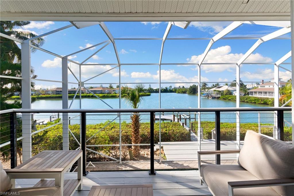 Image 3: View from Primary Suite/ terrace featuring a water view, a sunroom, and glass enclosure