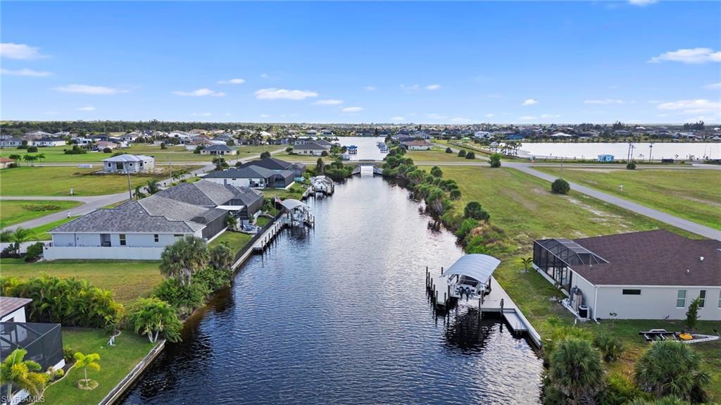Image 3: Aerial view of residential area featuring a nearby body of water
