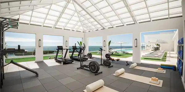 Image 4: Workout area featuring high vaulted ceiling and a water view