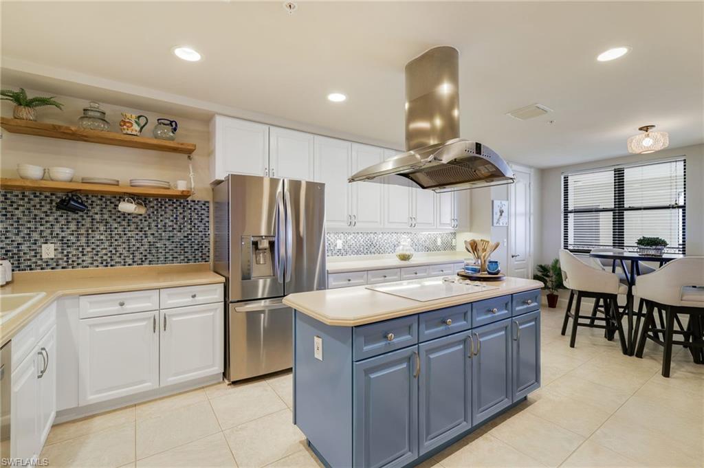 Image 4: Kitchen featuring 42" white cabinetry, open shelves, stainless steel appliances, center island and pantry