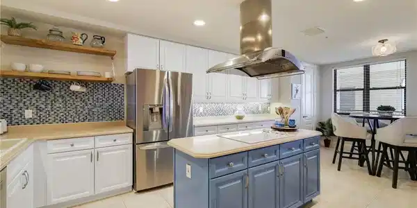 Image 4: Kitchen featuring 42" white cabinetry, open shelves, stainless steel appliances, center island and pantry
