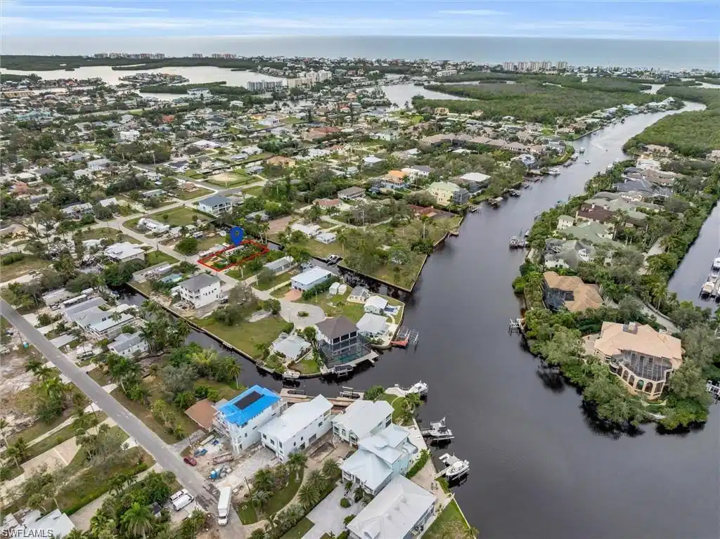 Image 1: Aerial view of residential area featuring a nearby body of water