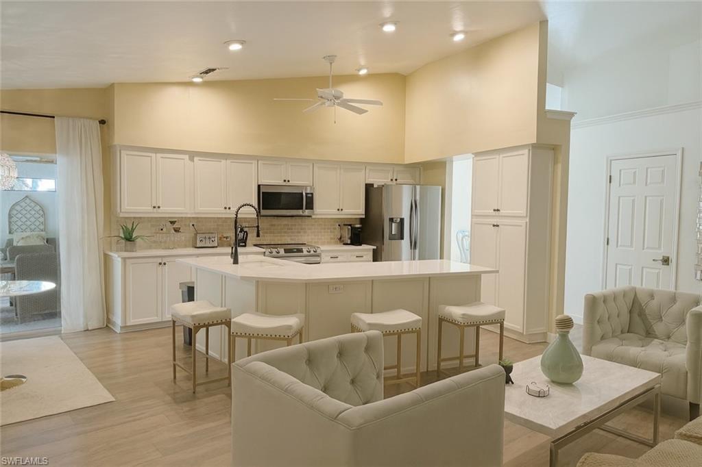 Image 3: Kitchen with high vaulted ceiling, stainless steel appliances, and a  kitchen island