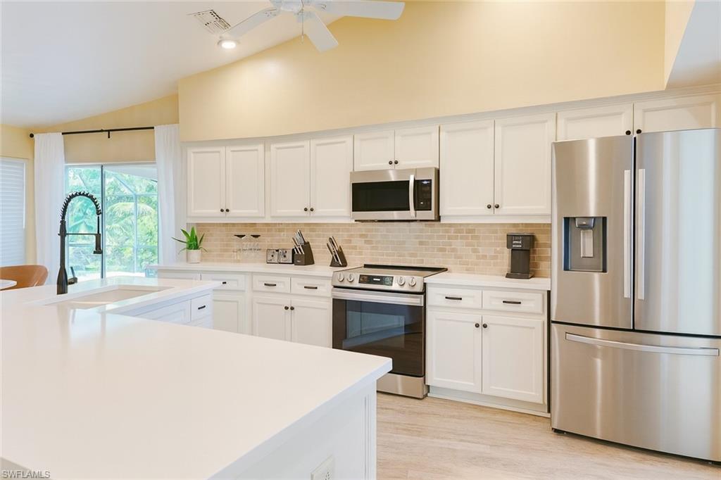 Image 4: Kitchen featuring stainless steel appliances, white cabinets, tasteful backsplash, light quartz countertops, and recessed lighting