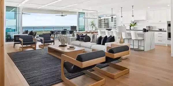 Image 3: Furnished 22nd-floor great room with expansive big-water views, featuring impact-rated pocketing doors that open wide to the terrace for seamless indoor-outdoor living