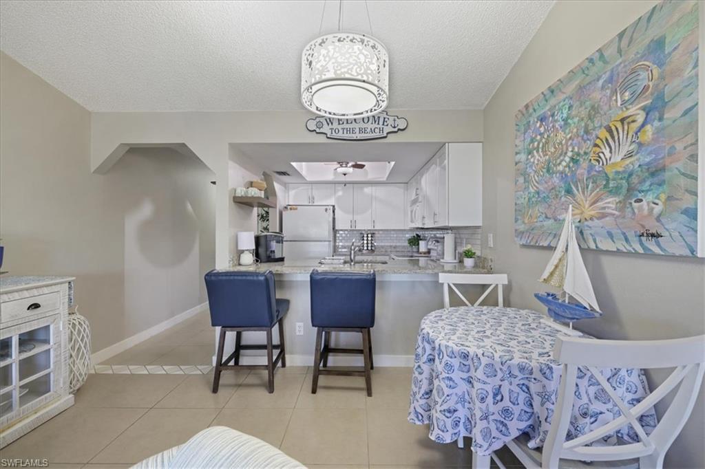 Image 4: Dining area featuring light tile patterned floors and a textured ceiling