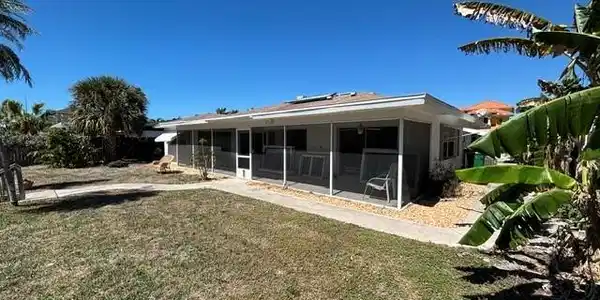 Image 3: Back of house with a yard and a sunroom