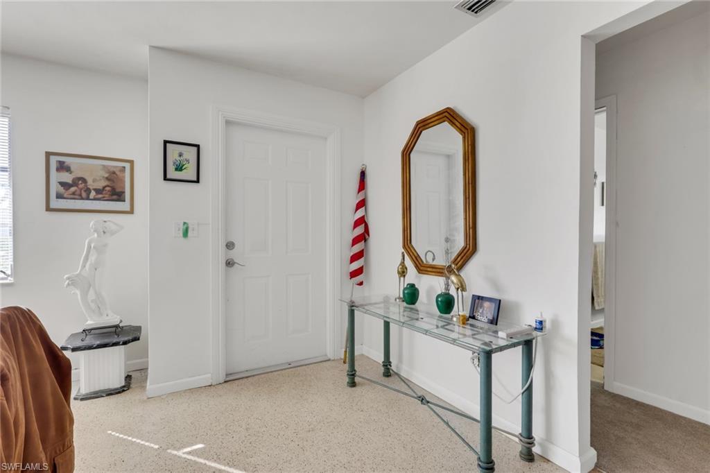Image 3: Foyer entrance featuring baseboards and dark speckled floor