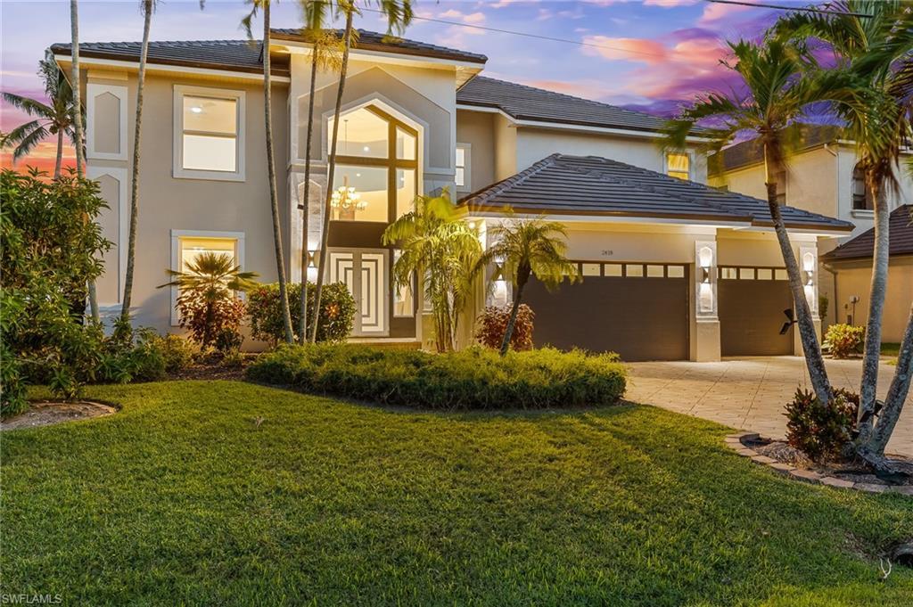 Image 2: View of front of property featuring stucco siding, driveway, a garage, and a tiled roof