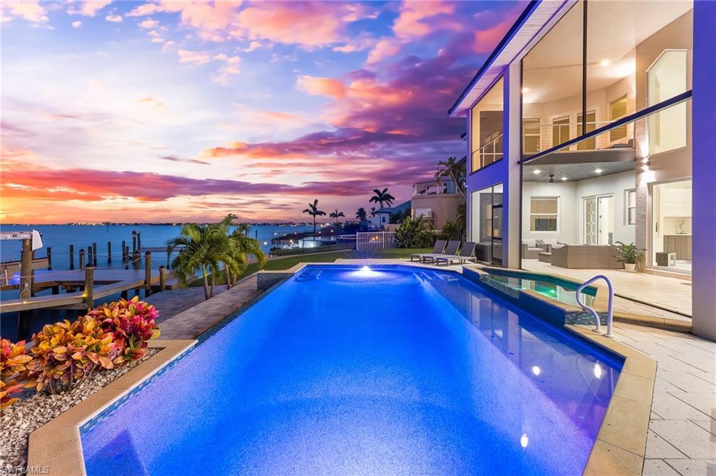 Image 4: View of pool with a water view, a pool with connected hot tub, a balcony, a patio area, and outdoor lounge area
