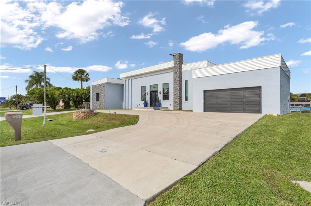 Image 3: Contemporary home featuring a front yard, driveway, stucco siding, and an attached garage