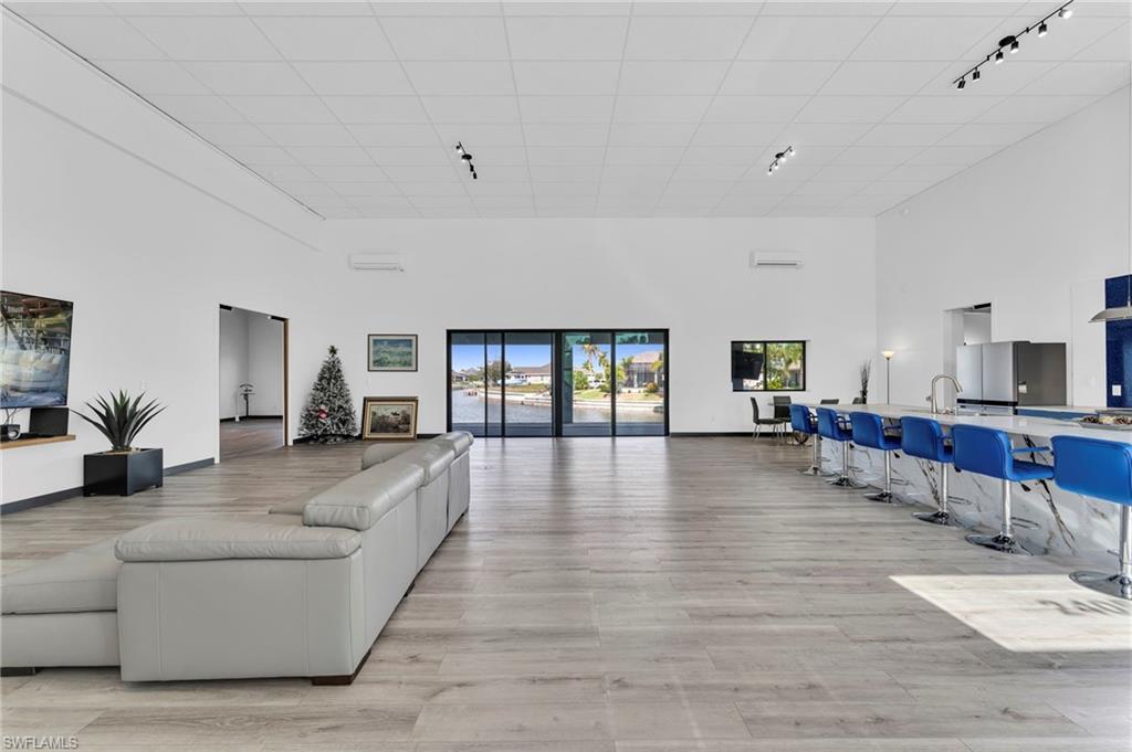 Image 4: Living area featuring a high ceiling, track lighting, and light wood-type flooring