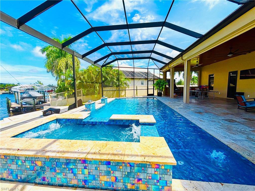 Image 1: Integrated pool / hot tub featuring a sunroom, a patio area, glass enclosure, and outdoor dining space