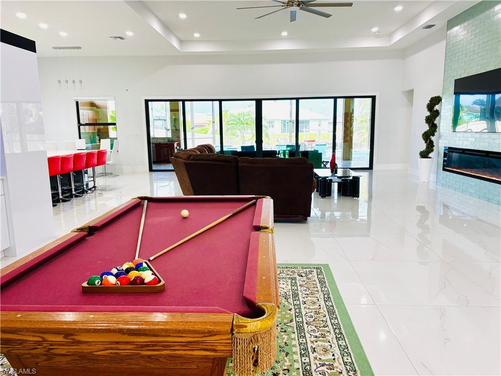 Image 4: Playroom with billiards, a large fireplace, a ceiling fan, plenty of natural light, and recessed lighting