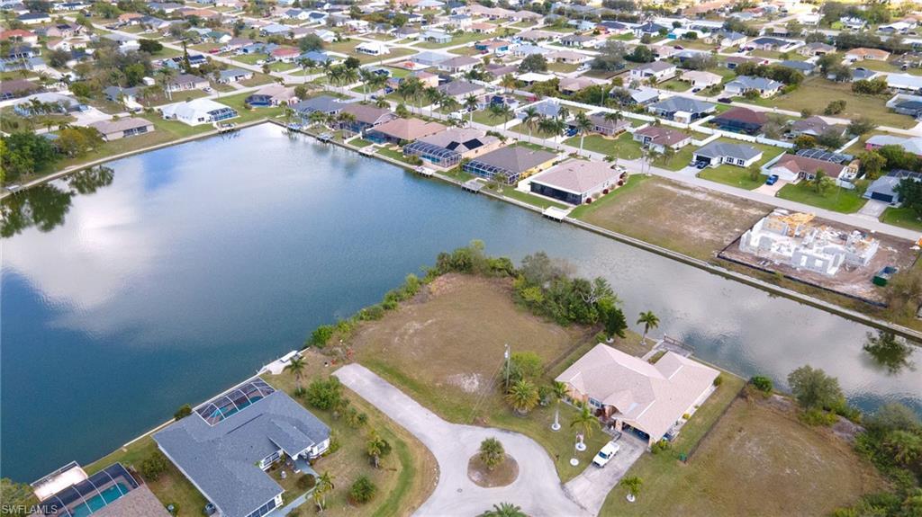 Image 2: Aerial view of property and surrounding area featuring a large body of water and nearby suburban area
