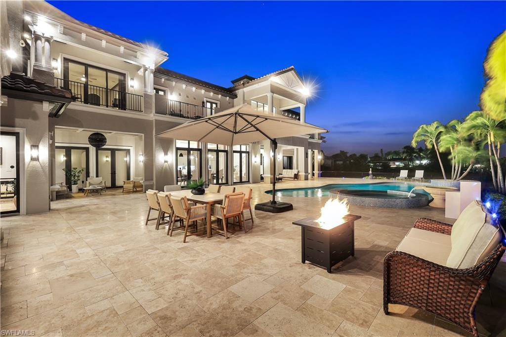 Image 3: Patio / terrace with a patio area, a pool with connected hot tub, an outdoor fire pit, and outdoor dining area