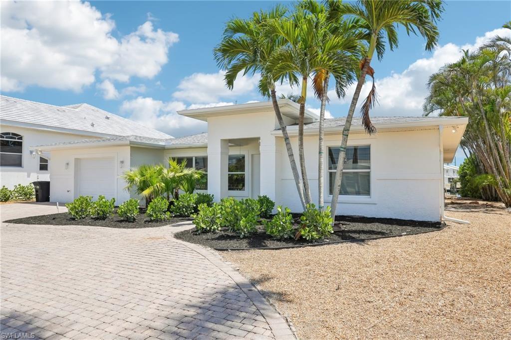 Image 2: View of front of house featuring decorative driveway, a garage, and stucco siding