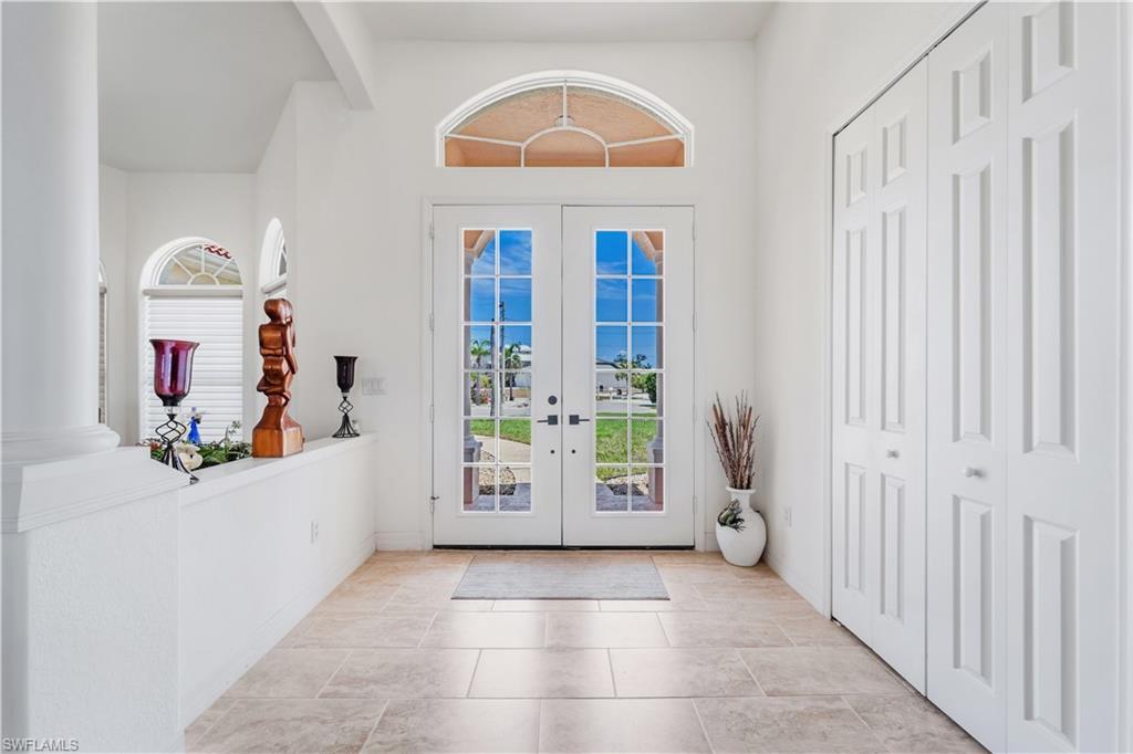 Image 3: Entrance foyer with french doors, high vaulted ceiling, beam ceiling, and baseboards