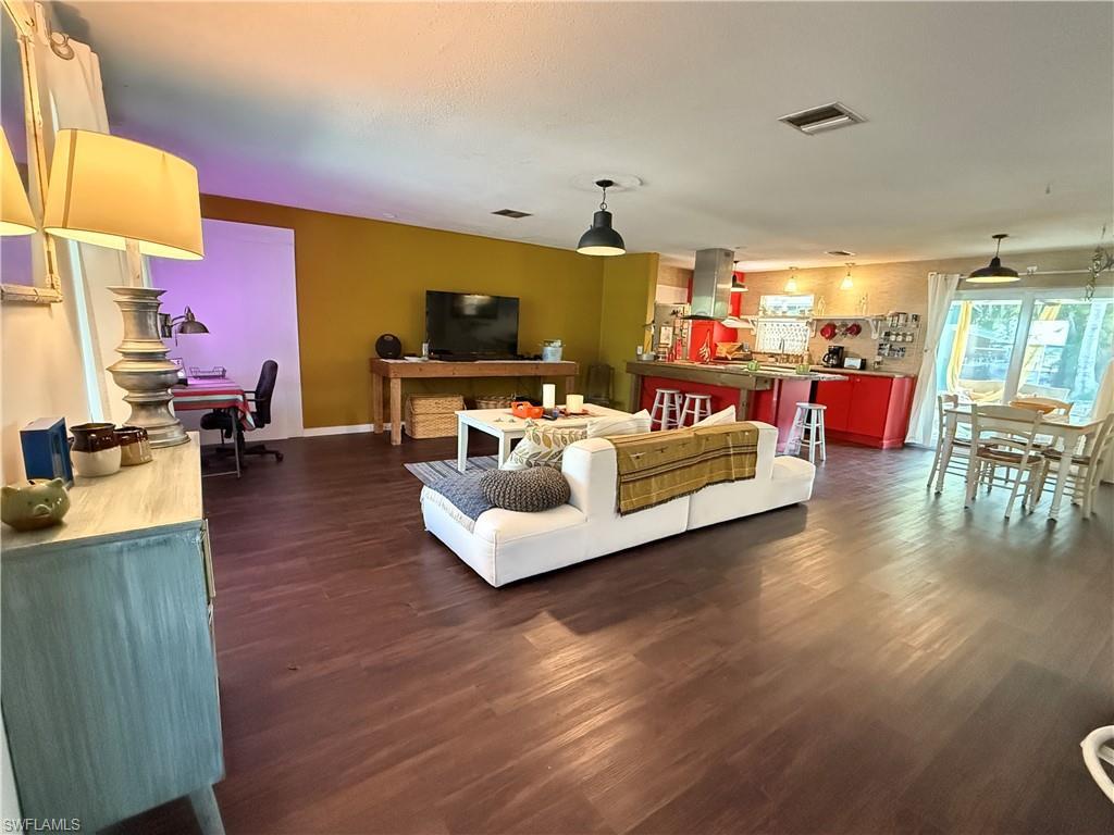 Image 3: Living room featuring dark wood finished floors and baseboards