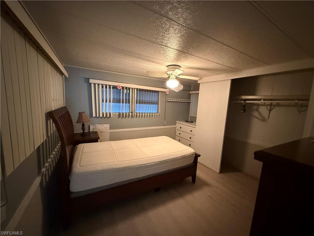 Image 4: Bedroom with ceiling fan, a closet, a textured ceiling, and wood finished floors