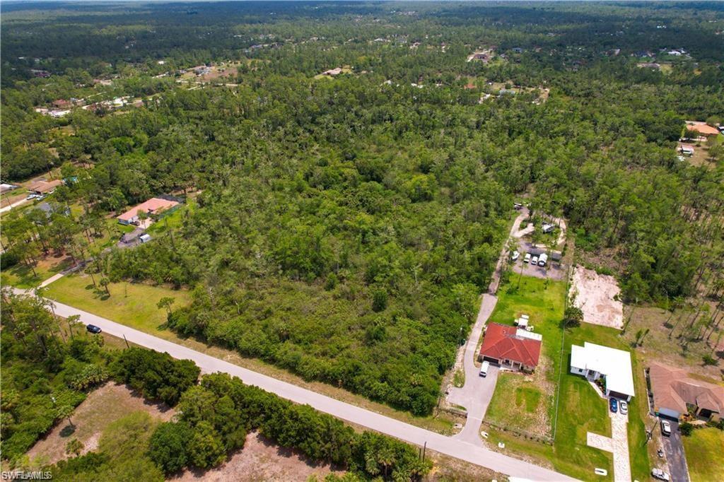 Image 2: Aerial view of property and surrounding area featuring a heavily wooded area