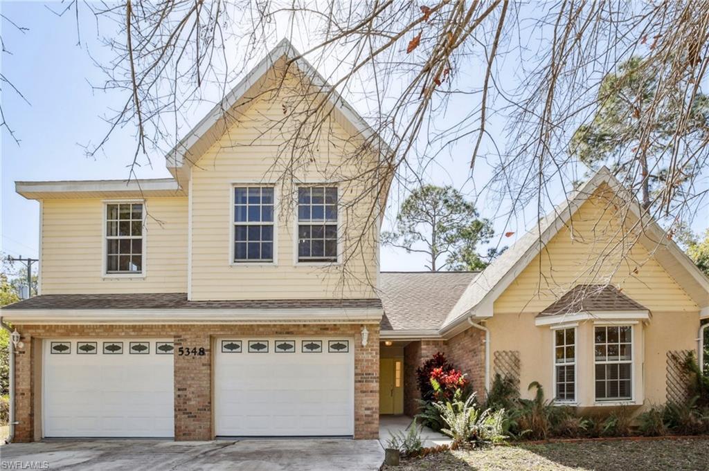 Image 3: View of front of home featuring brick siding, a garage, a shingled roof, and driveway