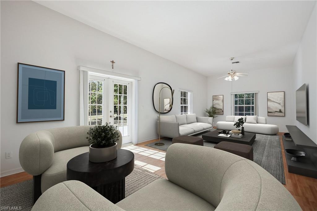 Image 4: VIRTUALLY Staged Living room with wood laminate floors, French doors, and healthy amount of natural light