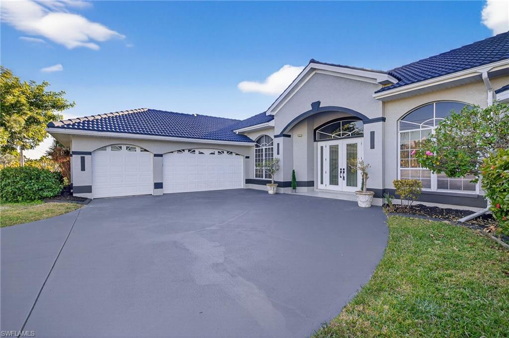 Image 2: View of front of property with french doors, concrete driveway, a tiled roof, and stucco siding