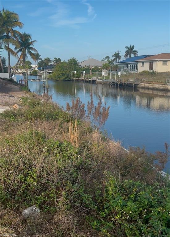 Image 4: Water view featuring a dock and nearby suburban area