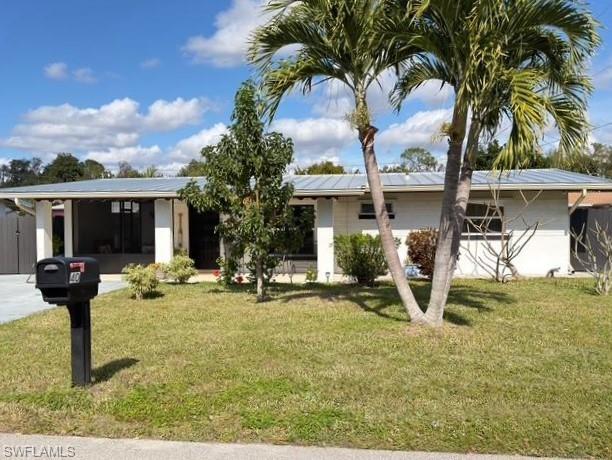 Image 1: Single story home featuring a front yard and solar panels