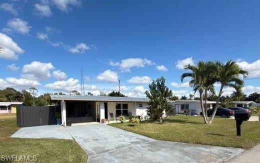 Image 3: Ranch-style house featuring a front lawn, driveway, and an attached carport