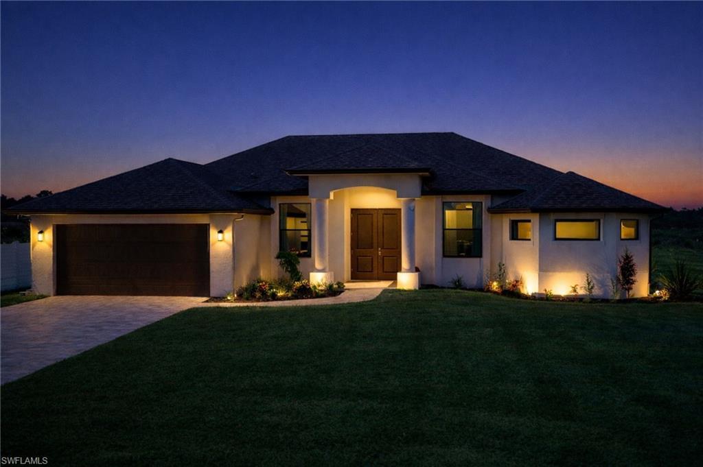 Image 1: Prairie-style house featuring a front lawn, stucco siding, driveway, and a garage