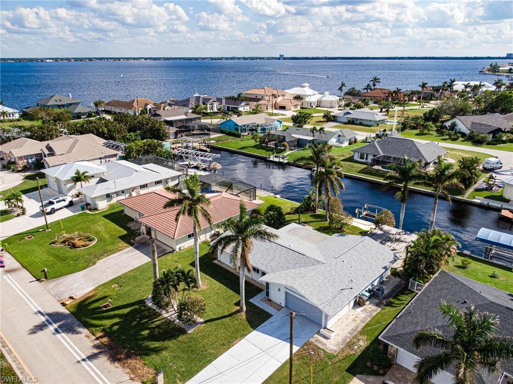 Image 1: Aerial view of residential area with a large body of water