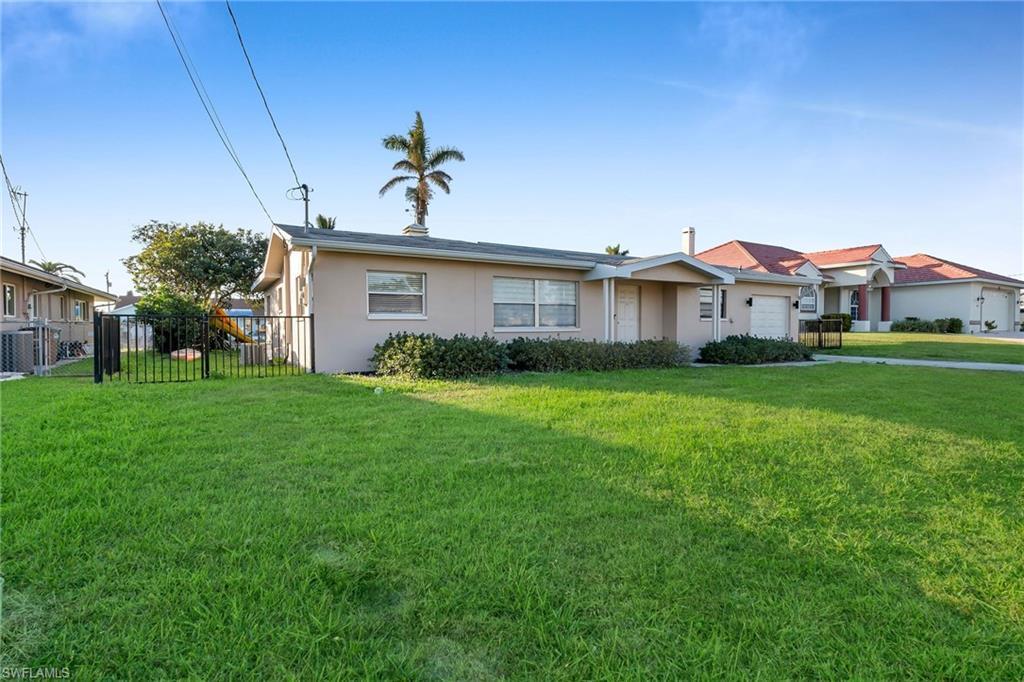 Image 2: View of front facade featuring central AC unit, a front lawn, and a garage