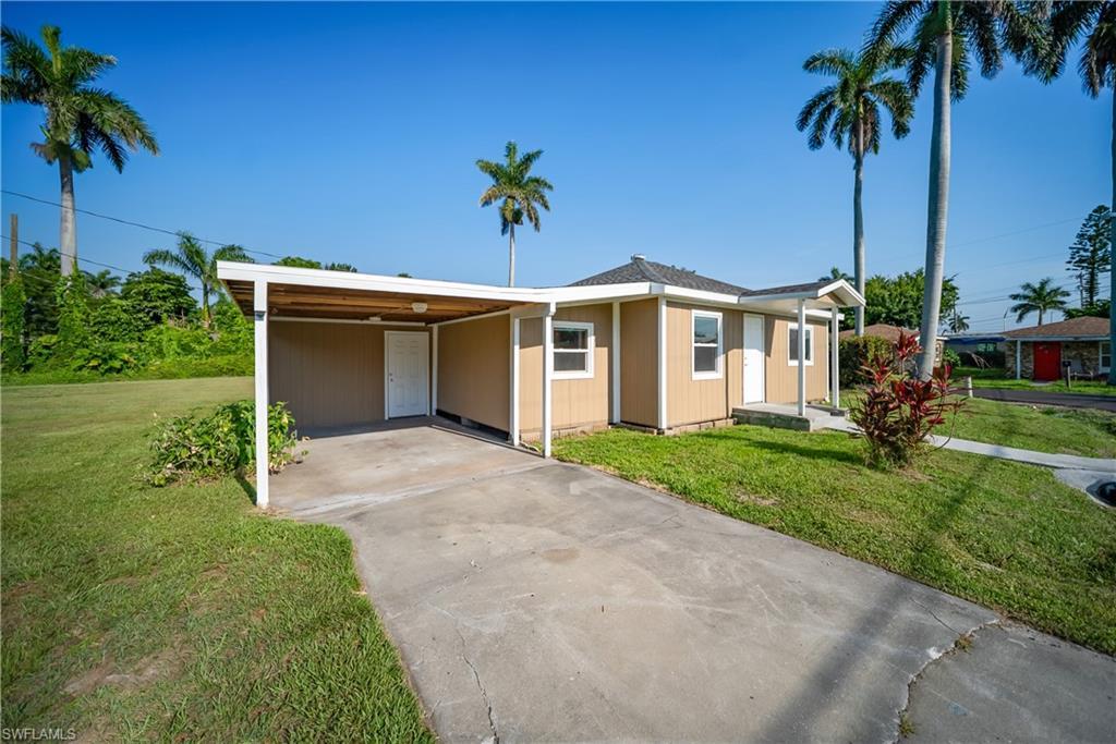 Image 3: Ranch-style home with a front yard, concrete driveway, and an attached carport