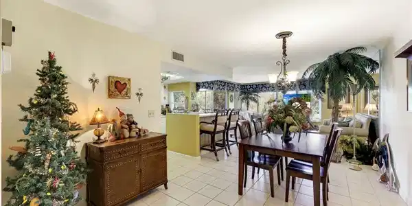 Image 4: Dining area featuring an inviting chandelier, light tile patterned floors, and visible vents