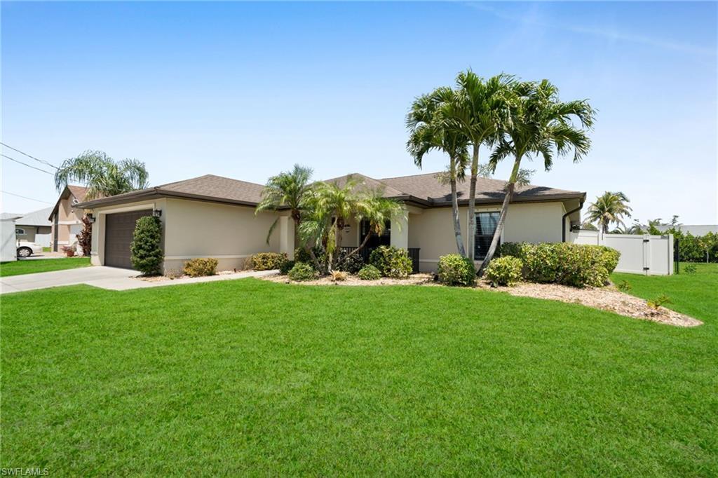 Image 2: Ranch-style home featuring a front lawn, stucco siding, driveway, and an attached garage