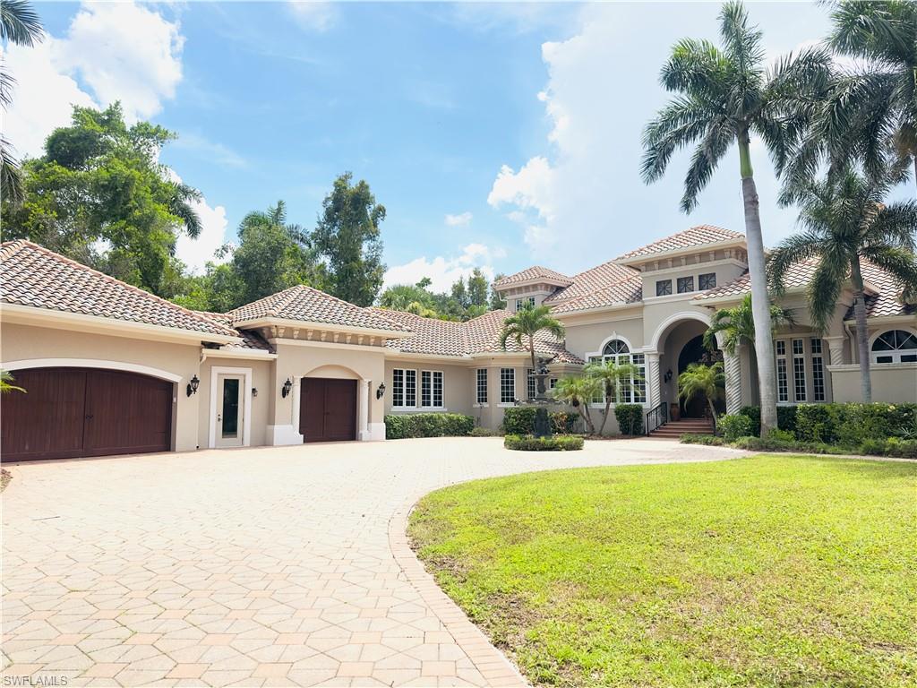 Image 2: Mediterranean / spanish-style home with a front yard, stucco siding, curved driveway, and a garage