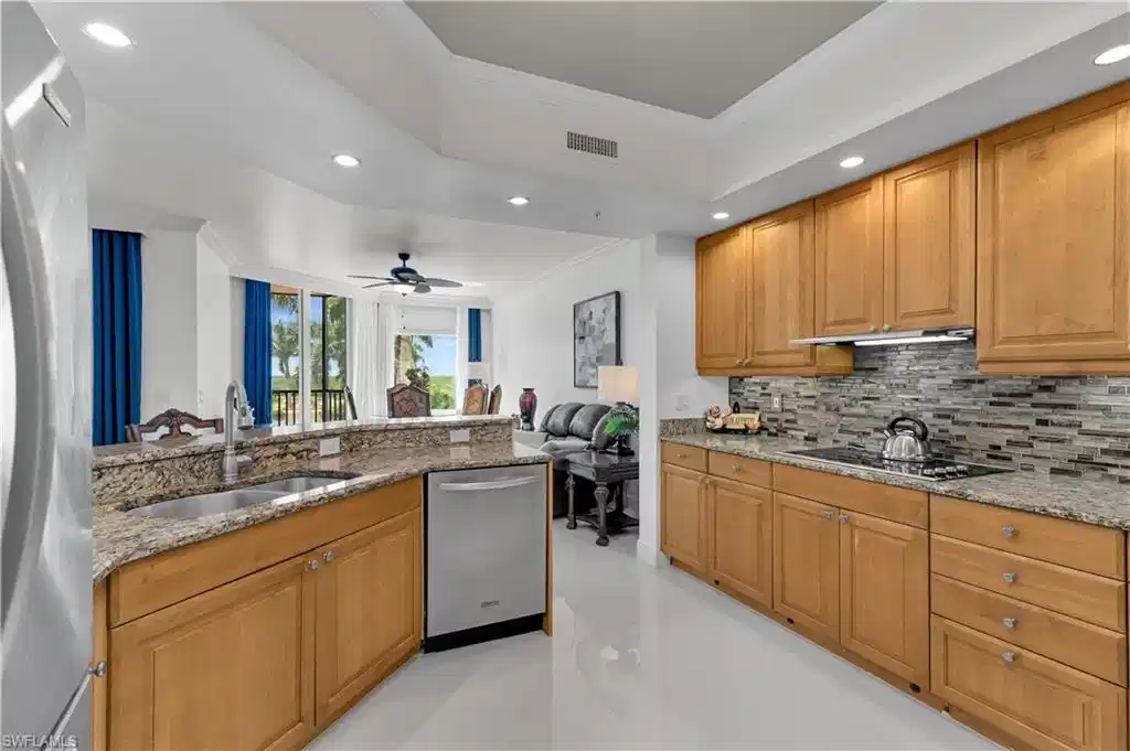 Image 1: Kitchen featuring ornamental molding, recessed lighting, appliances with stainless steel finishes, light stone countertops, and a raised ceiling
