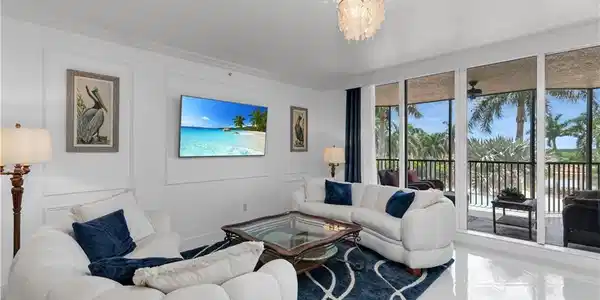 Image 4: Living room featuring a decorative wall, a wall of windows, a chandelier, and ornamental molding