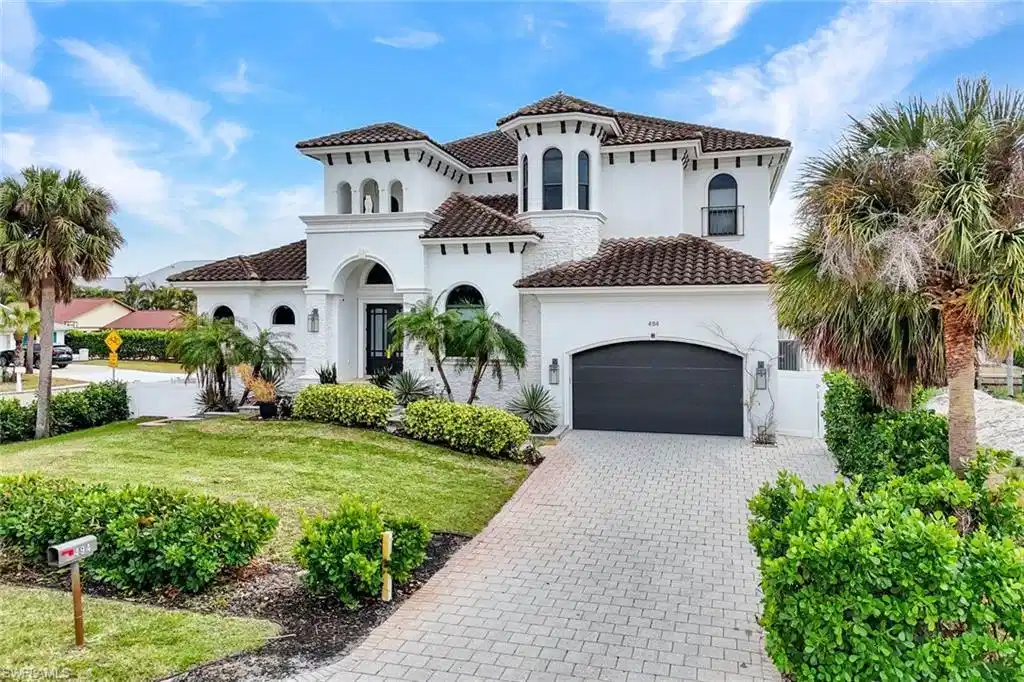 Image 1: Mediterranean / spanish-style house featuring decorative driveway, stucco siding, a front lawn, a tile roof, and a garage