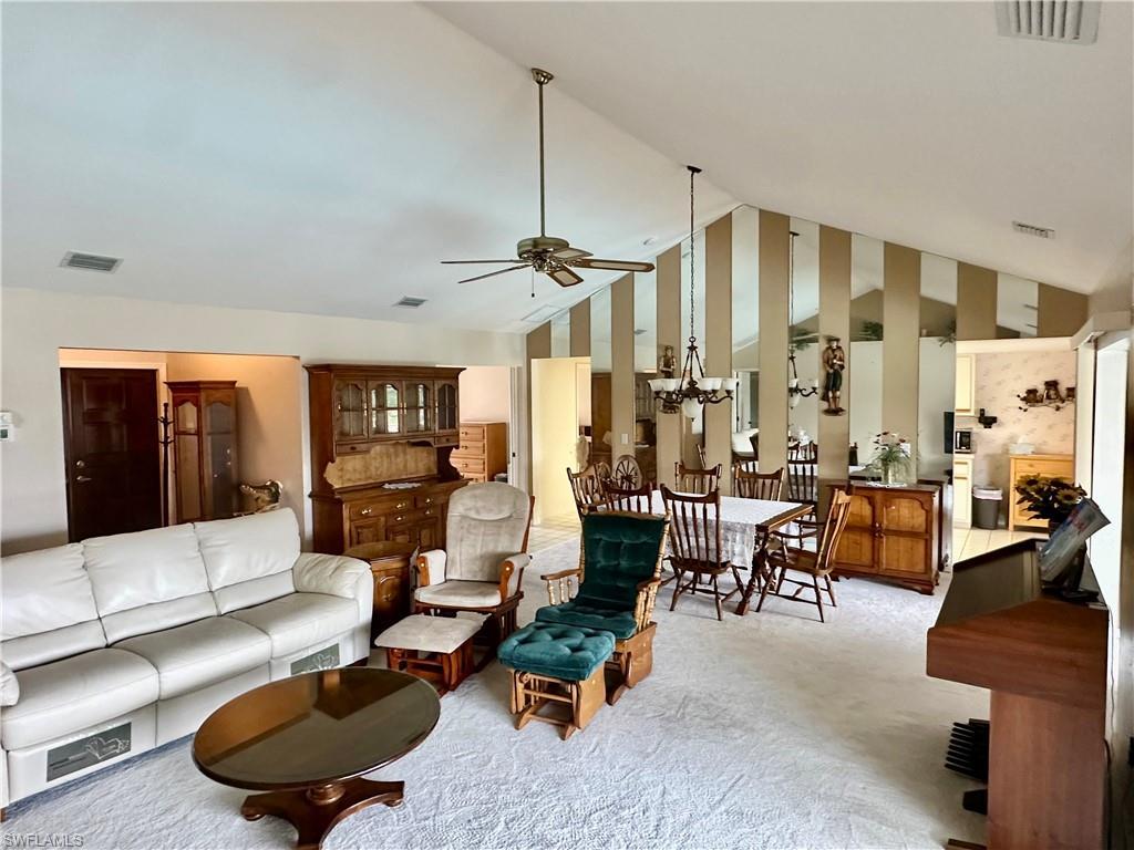 Image 4: Living area featuring carpet, ceiling fan, and high vaulted ceiling