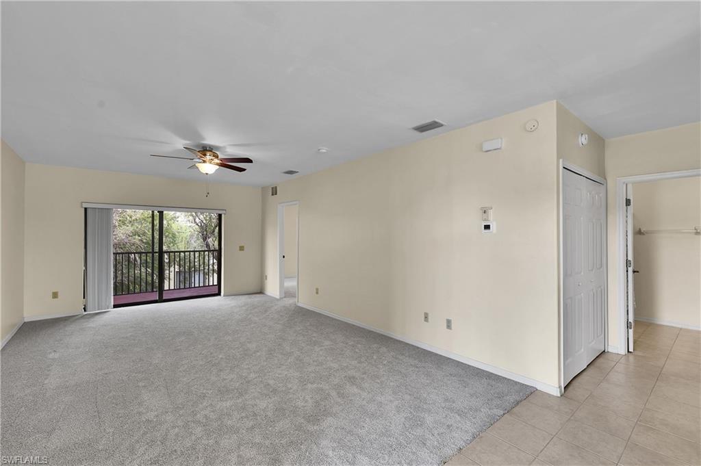 Image 4: Empty room with light carpet, ceiling fan, and light tile patterned flooring