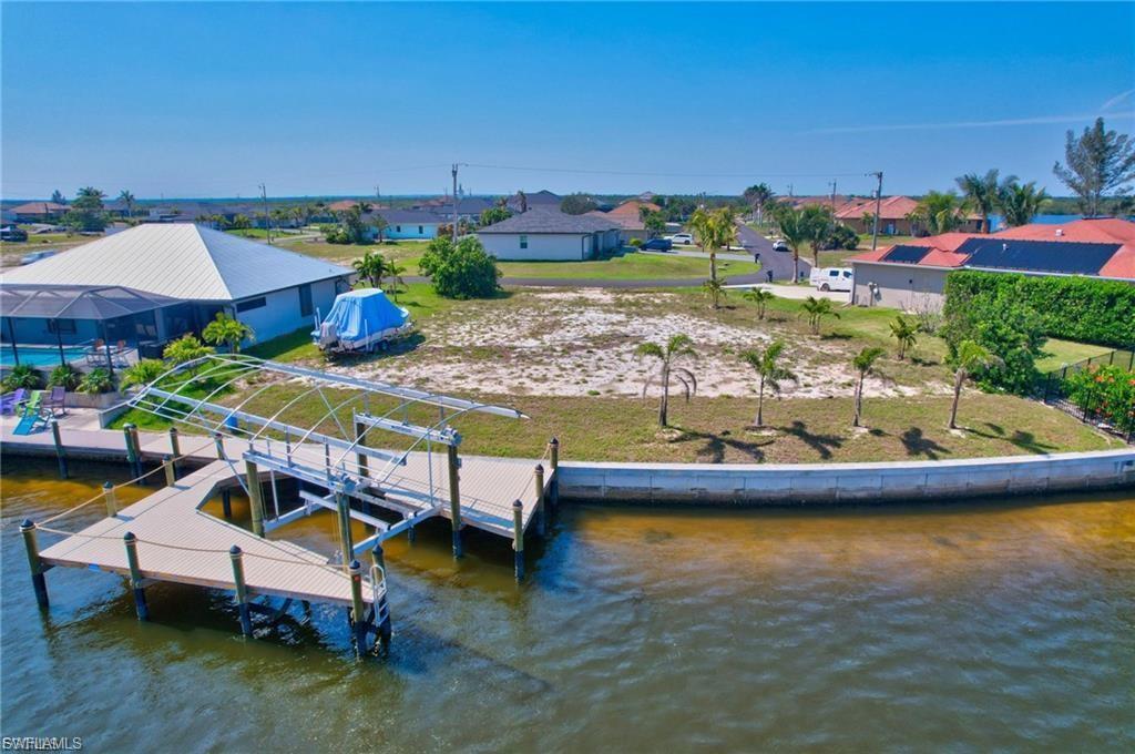 Image 2: Dock with boat lift, a residential view, and a water view