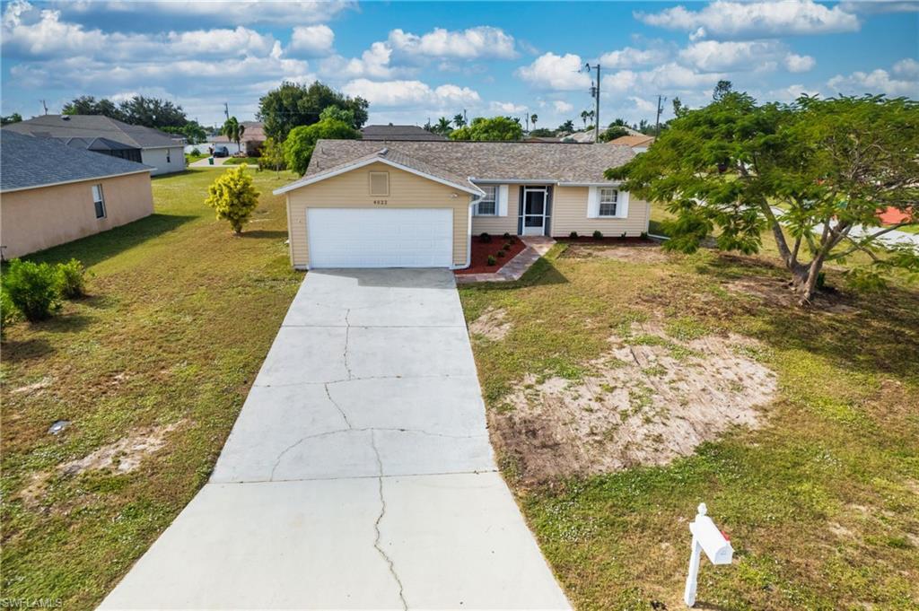 Image 2: Ranch-style home with driveway, a front yard, and an attached garage