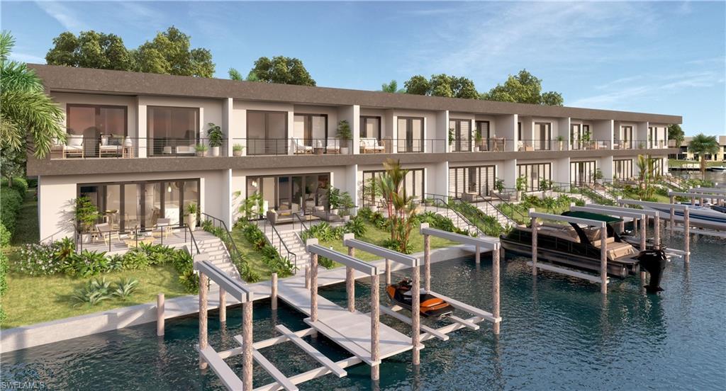 Image 3: Rear view of property with boat lift, stucco siding, a water view, and a balcony