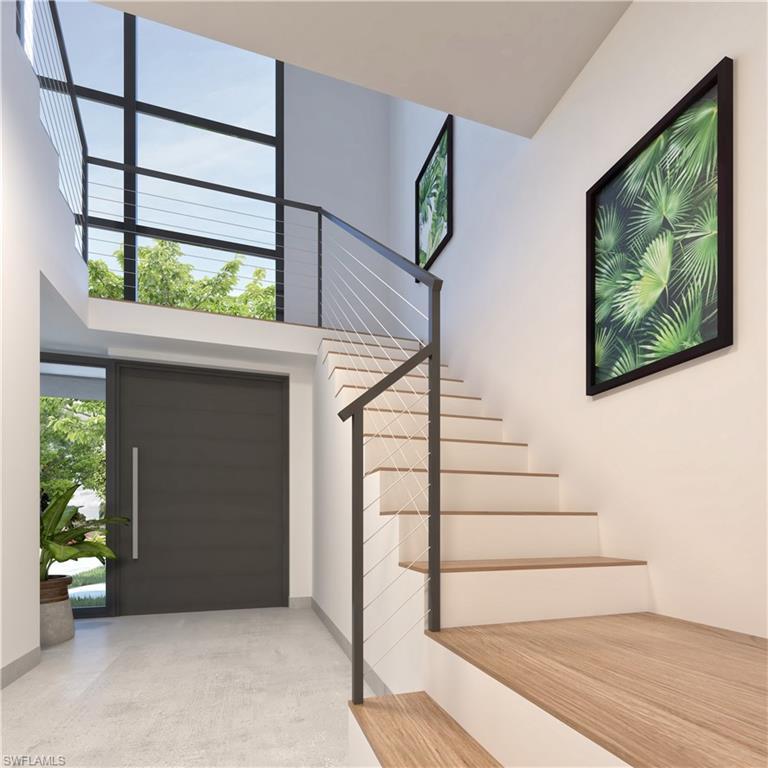 Image 4: Entrance foyer with a high ceiling, stairway, and concrete flooring